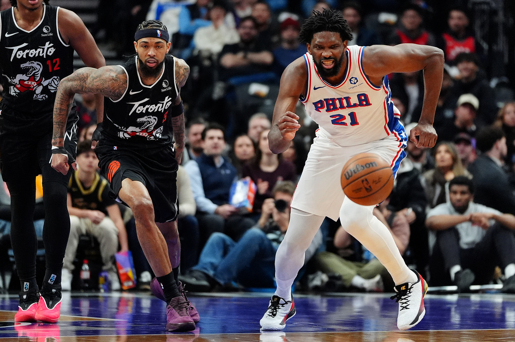 Toronto Raptors forward Brandon Ingram (3) and Philadelphia 76ers centre/forward Joel Embiid (21) vie for a loose ball during first half NBA basketball action in Toronto, Monday, Jan. 12, 2026. (Frank Gunn/The Canadian Press via AP)