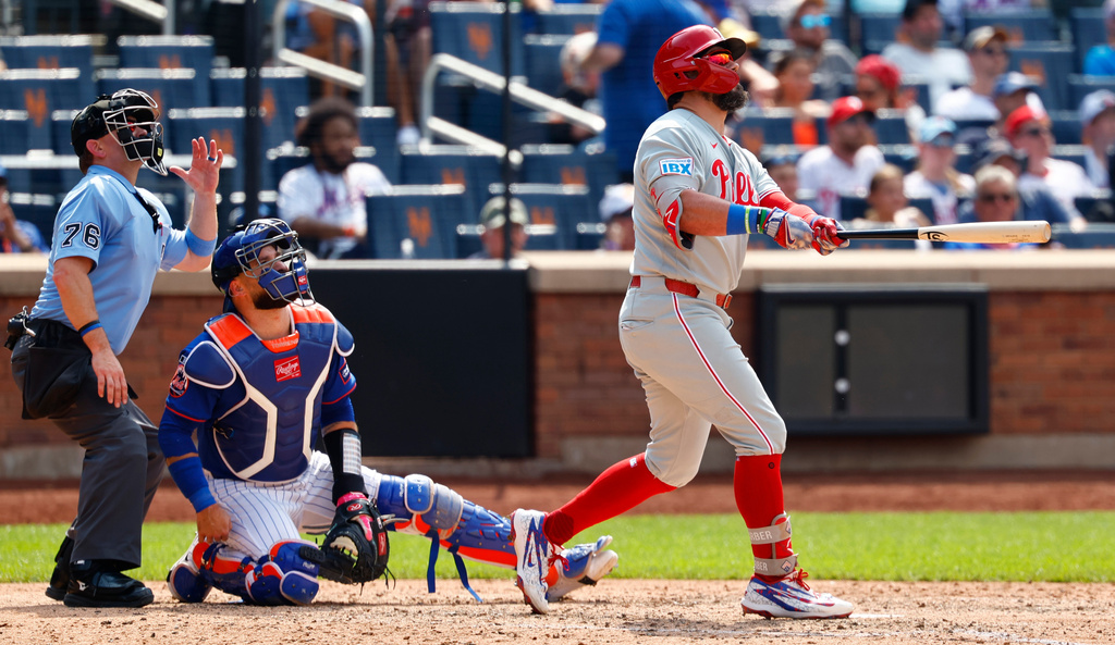 Philadelphia Phillies' Kyle Schwarber, right, watches his two-run home run against the New York Mets during the seventh inning of a baseball game, Sunday, June 28, 2026, in New York. (AP Photo/Noah K. Murray)