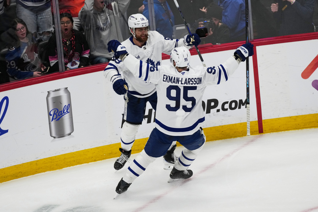 Toronto Maple Leafs defenseman Oliver Ekman-Larsson, front, congratulates right wing William Nylander after he scored the winning goal in overtime of an NHL hockey game against the Colorado Avalanche Monday, Jan. 12, 2026, in Denver. (AP Photo/David Zalubowski)