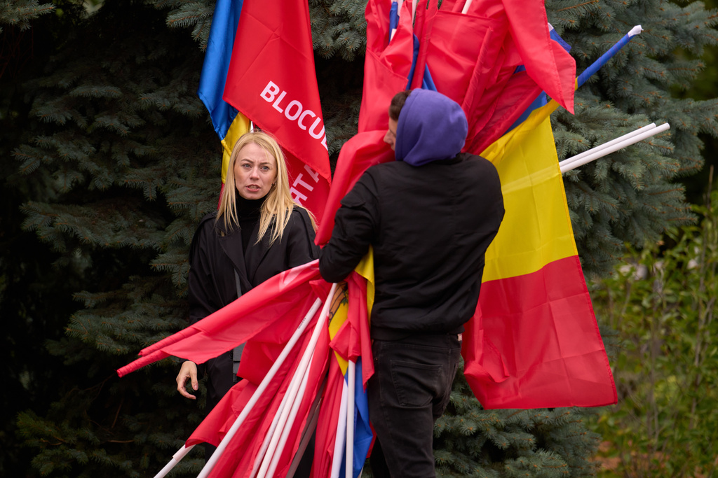 Activists gather flags at the end of a rally of the Russia-friendly Patriotic Electoral Bloc in Chisinau, Moldova, Thursday, Sept. 25, 2025, ahead of parliamentary elections taking place on Sept. 28. (AP Photo/Vadim Ghirda)