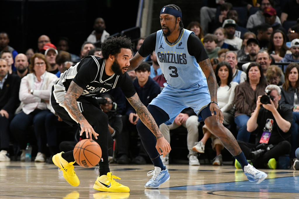 San Antonio Spurs forward Julian Champagnie (30) handles the ball against Memphis Grizzlies guard Kentavious Caldwell-Pope (3) in the first half of an NBA basketball game Tuesday, Jan. 6, 2026, in Memphis, Tenn. (AP Photo/Brandon Dill)