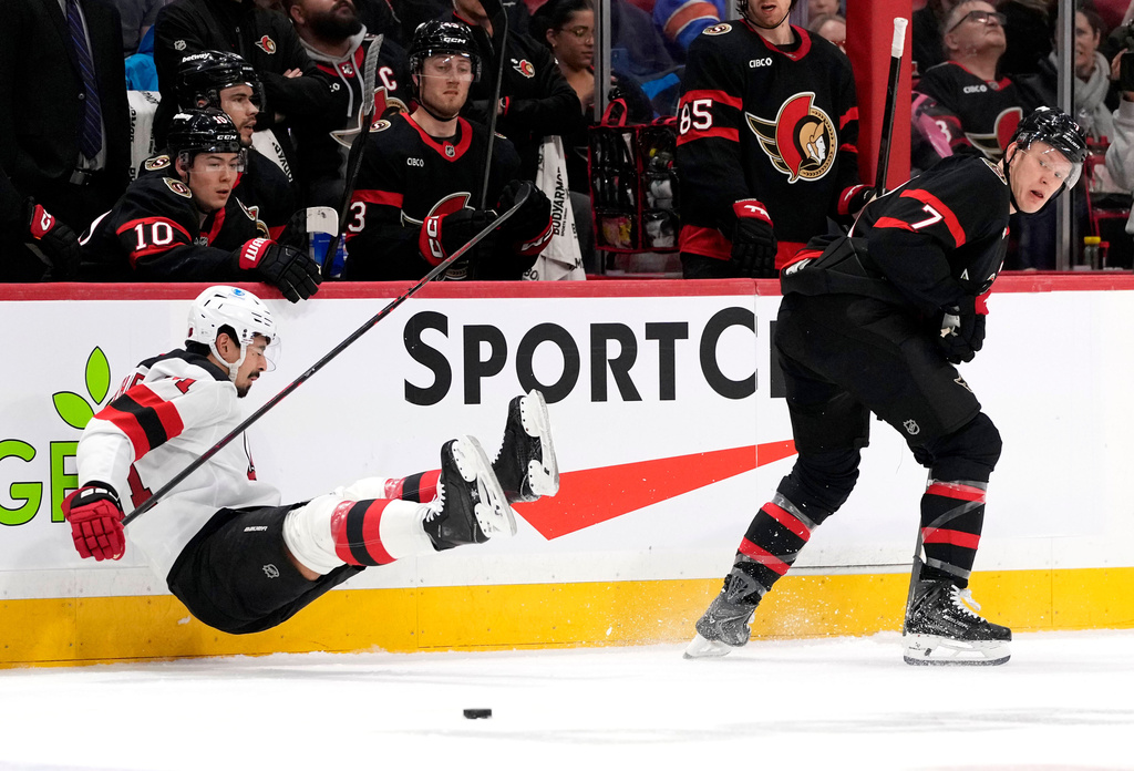 New Jersey Devils' Jonas Siegenthaler (71) falls after taking a hit along the boards from Ottawa Senators' Brady Tkachuk (7) during second period NHL hockey action in Ottawa, Ontario, Saturday, Jan. 31, 2026. (Justin Tang/The Canadian Press via AP)