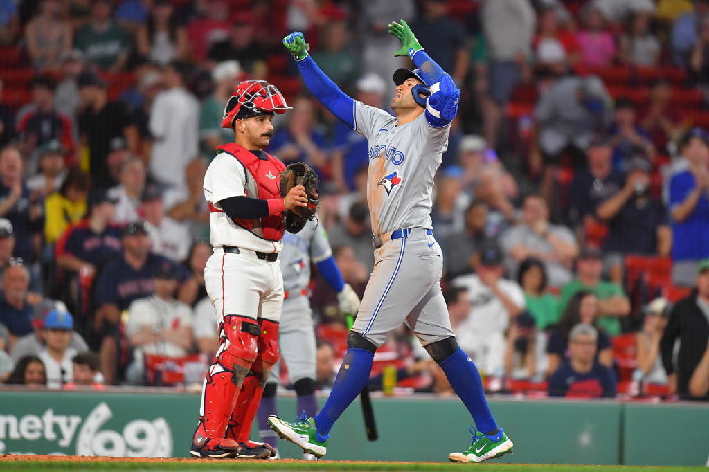 Toronto Blue Jays' George Springer, right, celebrates in front of Boston Red Sox catcher Mickey Gasper, left, as he arrives home after hitting a two-run home run in the ninth inning of a baseball game, Tuesday, June 16, 2026, in Boston. (AP Photo/Steven Senne)