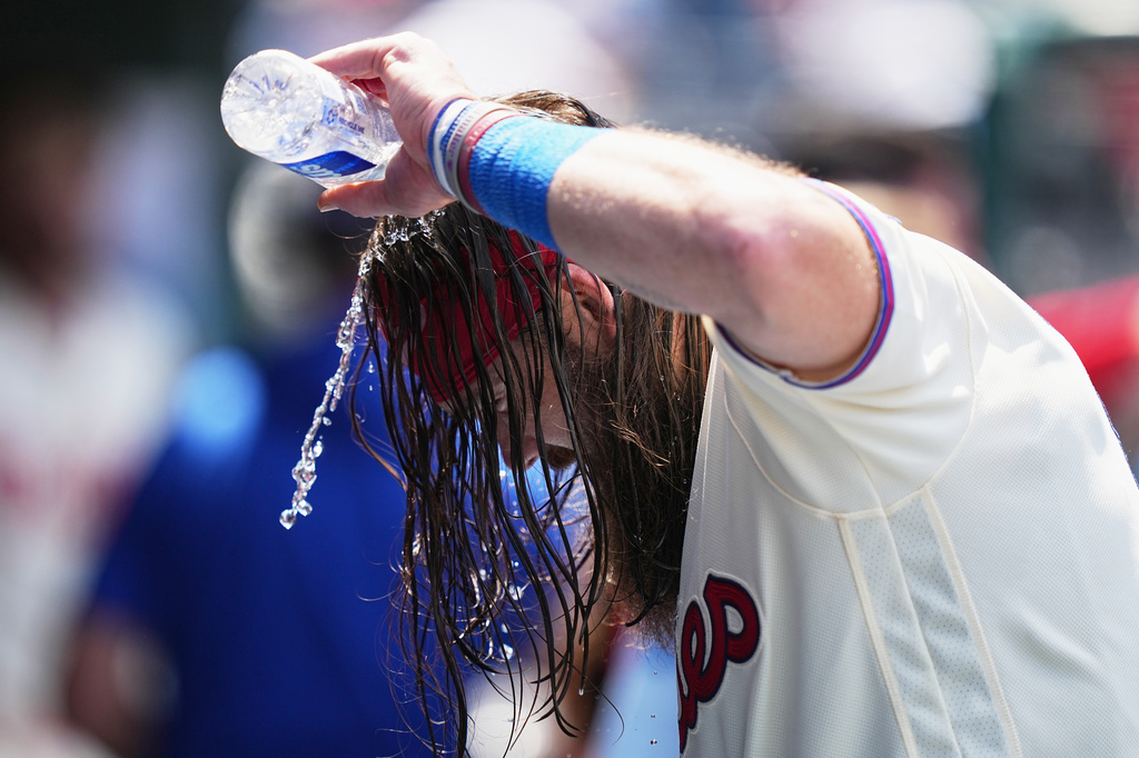 Philadelphia Phillies' Brandon Marsh pours water over his head to cool off during the fifth inning of a baseball game against the Cincinnati Reds, Wednesday, May 20, 2026, in Philadelphia. (AP Photo/Matt Rourke)