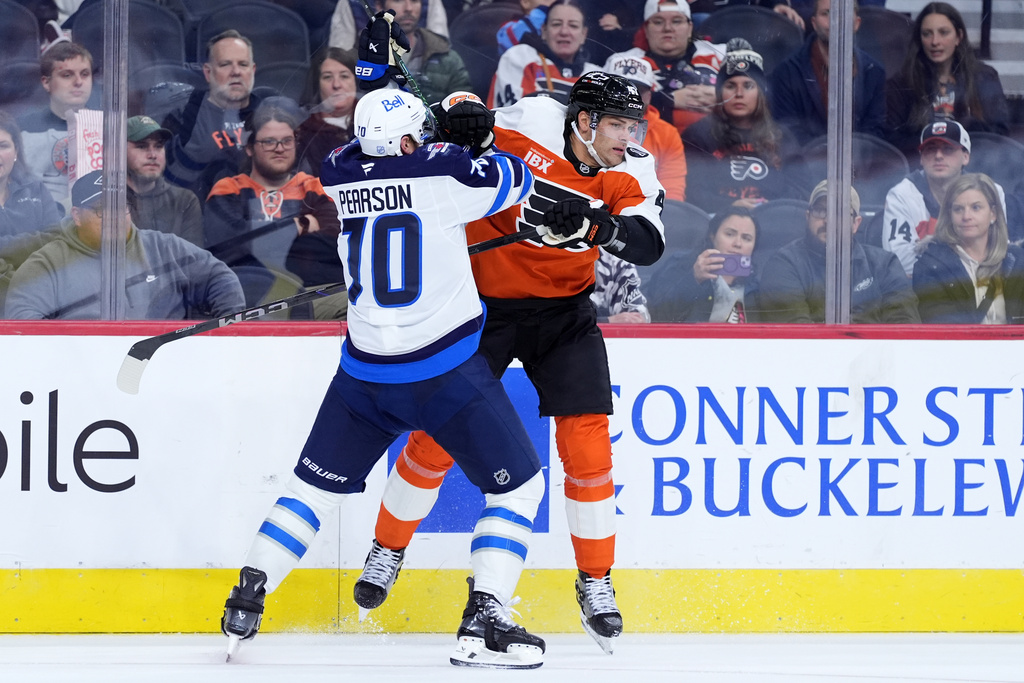 Philadelphia Flyers' Noah Juulsen, right, and Winnipeg Jets' Tanner Pearson collide during the second period of an NHL hockey game, Thursday, Oct. 16, 2025, in Philadelphia. (AP Photo/Matt Slocum)