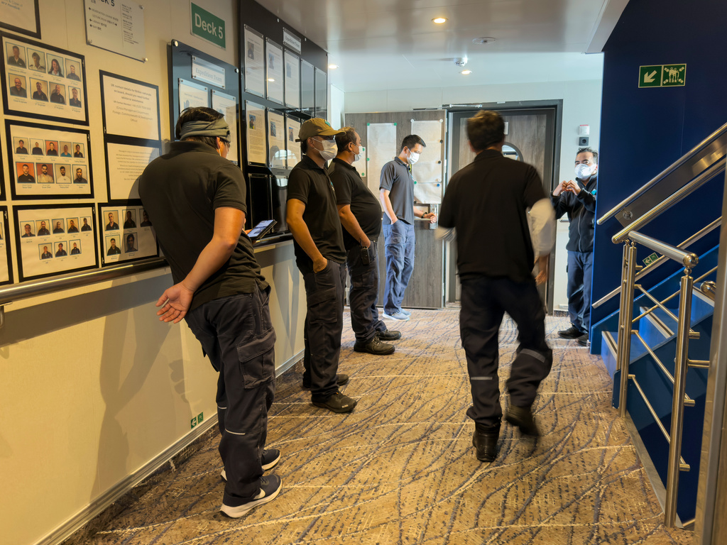 Crew members of the hantavirus-stricken cruise ship, MV Hondius, wait their turns for a first interview with epidemiologists, during the voyage to Spain's port of Tenerife, May 6, 2026. (AP Photo)