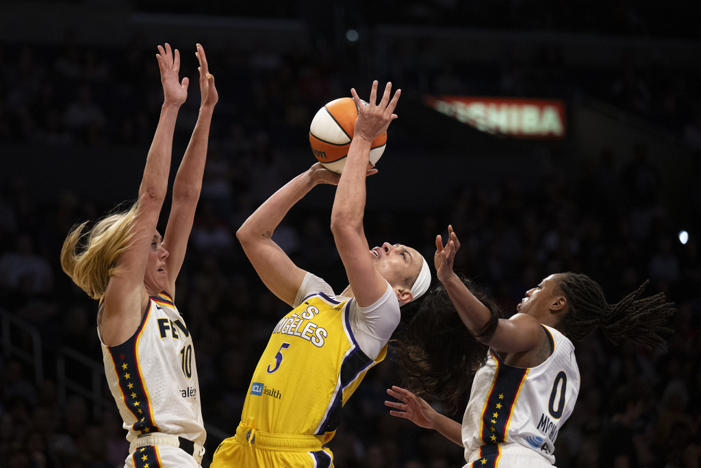 Los Angeles Sparks forward Dearica Hamby (5) shoots under pressure as Indiana Fever guard Lexie Hull (10) and guard Kelsey Mitchell (0) defend during the first half of a WNBA basketball game Friday, Aug. 29, 2025, in Los Angeles. (AP Photo/Kyusung Gong)