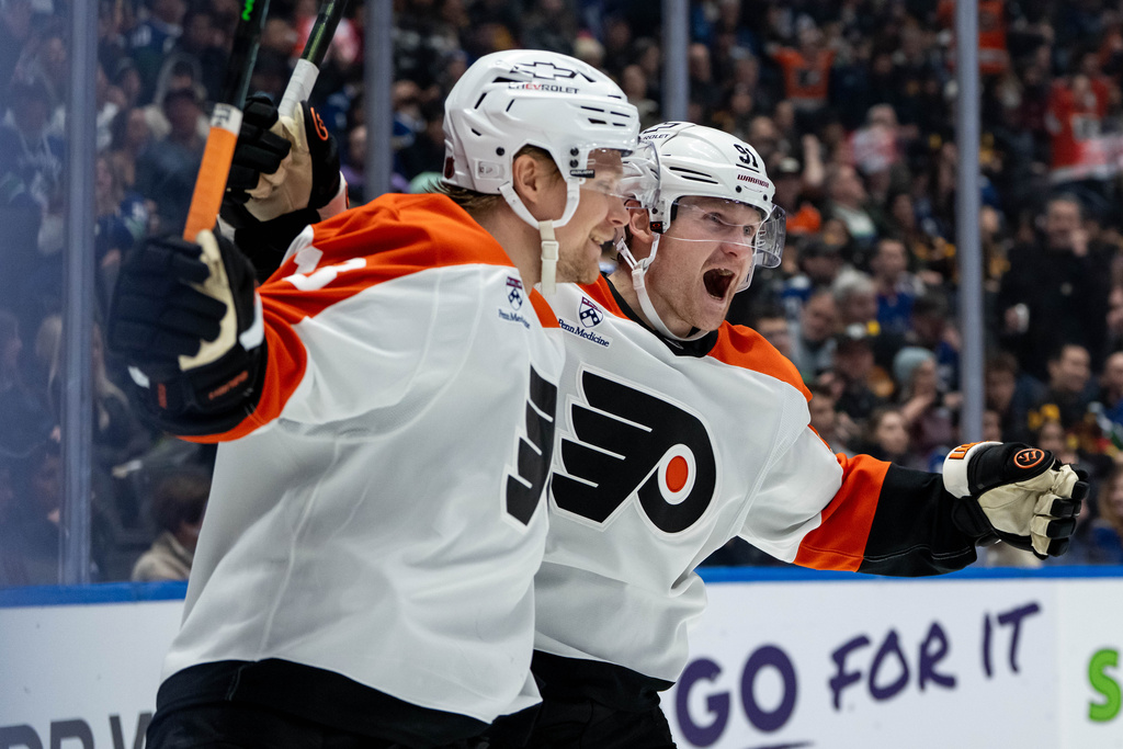Philadelphia Flyers' Carl Grundstrom (91) celebrates his goal against the Vancouver Canucks with Rodrigo Abols (18) during the second period of an NHL hockey game in Vancouver, B.C., Tuesday, Dec. 30, 2025. (Ethan Cairns/The Canadian Press via AP)