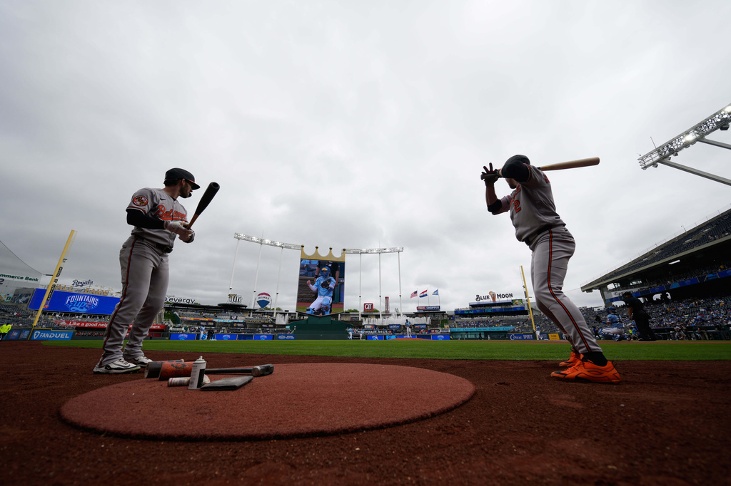 Baltimore Orioles' Taylor Ward, left, and Gunnar Henderson (2) warm up on deck before a baseball game against the Kansas City Royals, Wednesday, April 22, 2026, in Kansas City, Mo. (AP Photo/Charlie Riedel)