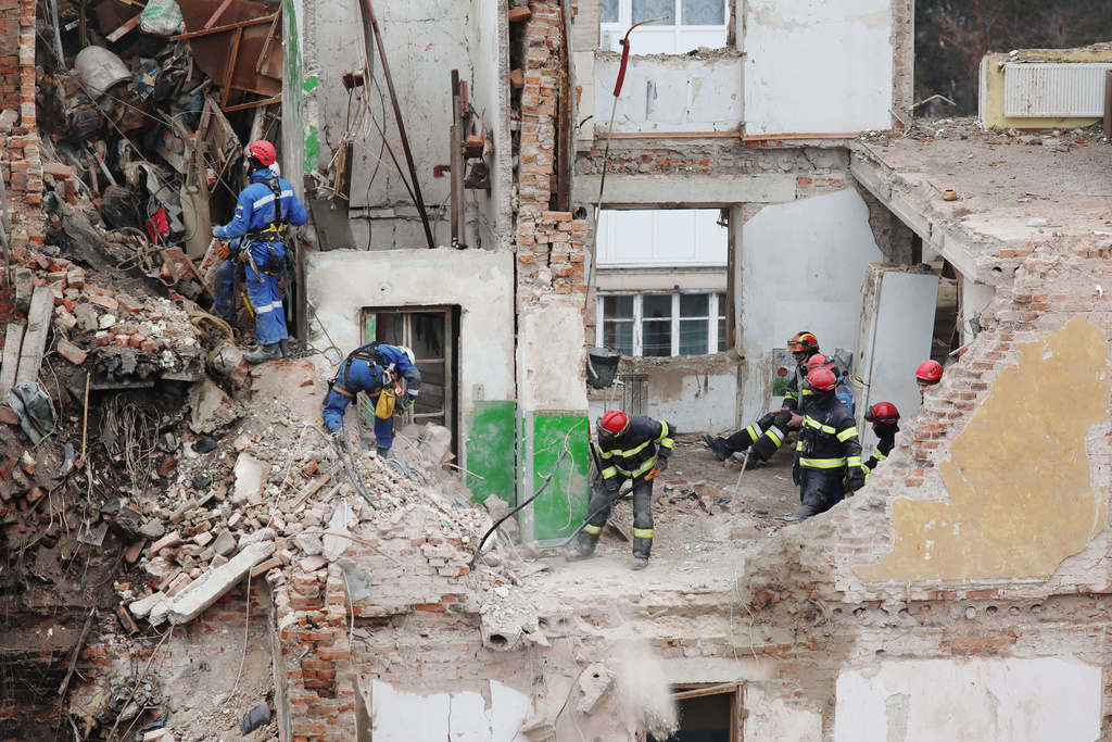 Rescue workers clear the rubble of a residential building which was heavily damaged by a Russian strike on Ternopil, Ukraine, Friday, Nov. 21, 2025. (AP Photo/Vlad Kravchuk)