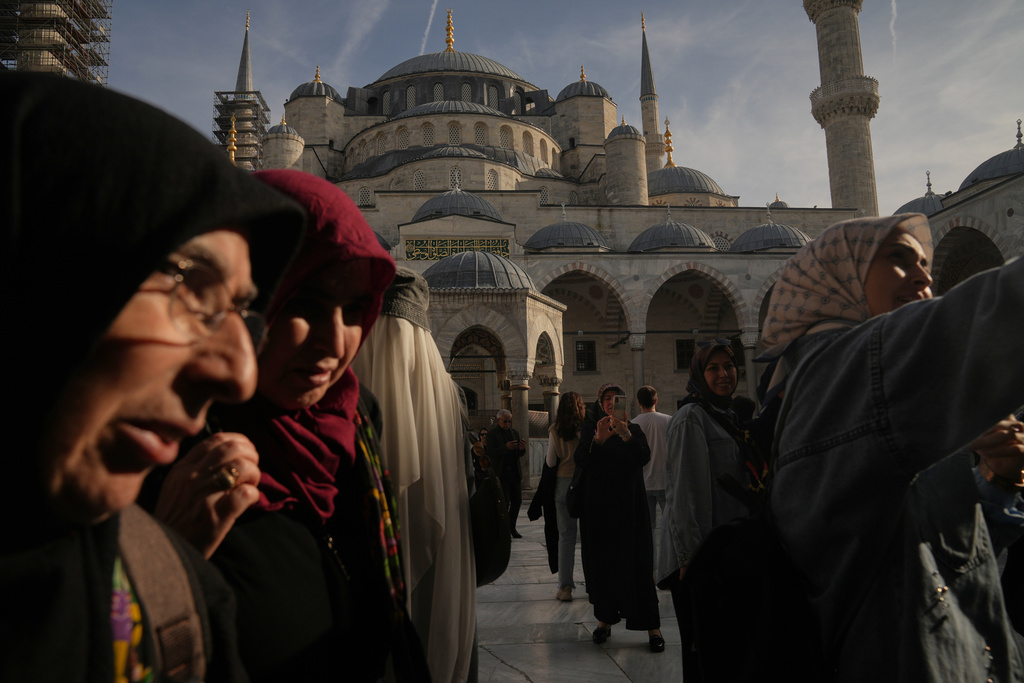 Locals and tourists visit the Ottoman-era Sultan Ahmed or Blue Mosque, in Istanbul, Turkey, Friday, Nov. 21, 2025, ahead of the visit of Pope Leo XIV to Turkey. (AP Photo/Francisco Seco)