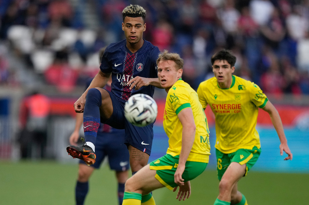 PSG's Desire Doue, left, and Nantes' Nicolas Cozza challenge for the ball during the French League One soccer match between Paris Saint-Germain and Nantes in Paris, France, Wednesday, April 22, 2026. (AP Photo/Michel Euler)