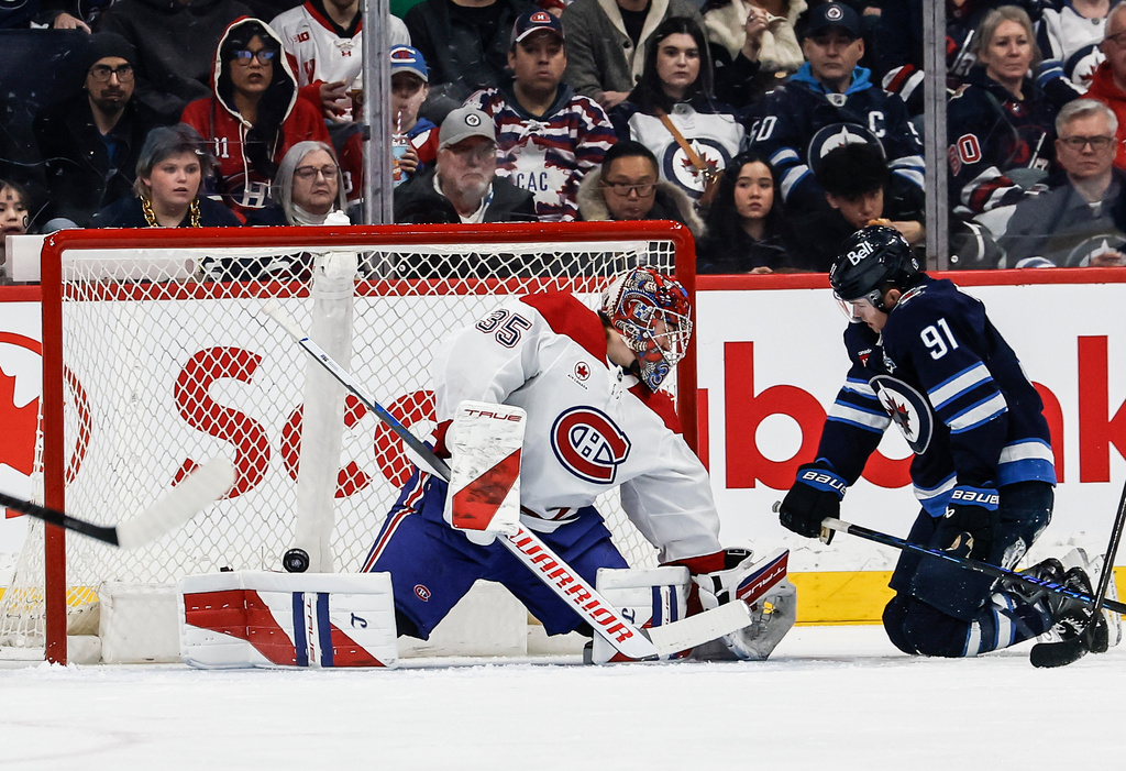 Winnipeg Jets' Kyle Connor scores on Montreal Canadiens goaltender Samuel Montembeault (35) as Cole Perfetti (91) looks on during the first period of an NHL hockey game in Winnipeg, Manitoba, Wednesday, Feb. 4, 2026. (John Woods/The Canadian Press via AP)