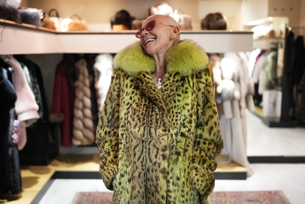 Paola De Leidi poses for a photo wearing a fur coat after an interview with The Associated Press in the Pajaro shop, in Cortina d'Ampezzo, Italy, Saturday, Feb. 14, 2026. (AP Photo/Alessandra Tarantino)