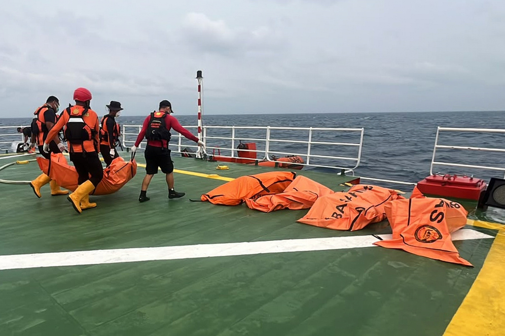 In this photo released by Indonesia's National Search and Rescue Agency (BASARNAS), rescuers carry the body of a victim of a ferry capsize in rough seas earlier this month, aboard a search-and-rescue vessel in the Java Sea, Indonesia, Friday, Sept. 25, 2026. (BASARNAS via AP)