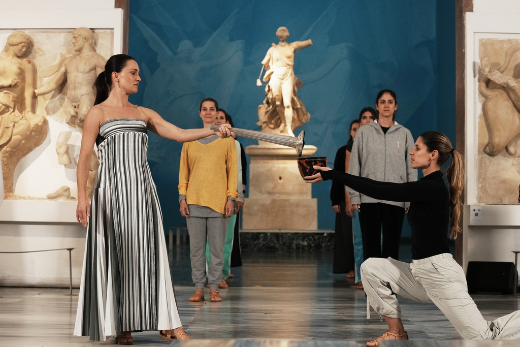 Actress Mary Mina, left, playing the role of high priestess, and Ioanna Strati playing the role of Estiada perform during the final rehearsal ahead of the flame lighting for the Milan Cortina 2026 Winter Olympics, at the archaeological museum of Olympia, Greece, Tuesday, Nov. 25, 2025. (AP Photo/Thanassis Stavrakis)
