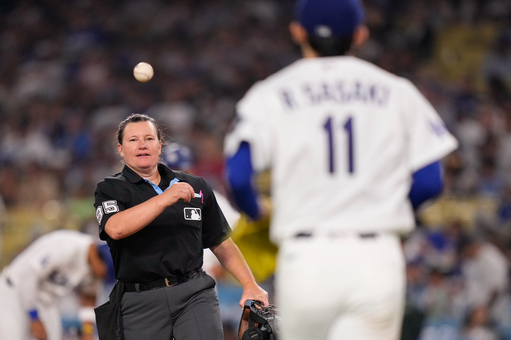 Home plate umpire Jen Pawol tosses a ball to Los Angeles Dodgers starting pitcher Roki Sasaki as he comes out for the sixth inning of a baseball game against the Los Angeles Angels, Friday, June 5, 2026, in Los Angeles. (AP Photo/Mark J. Terrill)