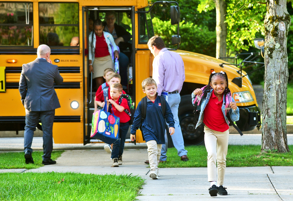 FILE - Second-grader Aaminah Ingram-Kirk, 7, leads the way off the bus for the first day of school at Bishop McCort Catholic Elementary West on Tioga Street in Johnstown, Pa., Aug. 21, 2024. (Thomas Slusser/The Tribune-Democrat via AP, File)