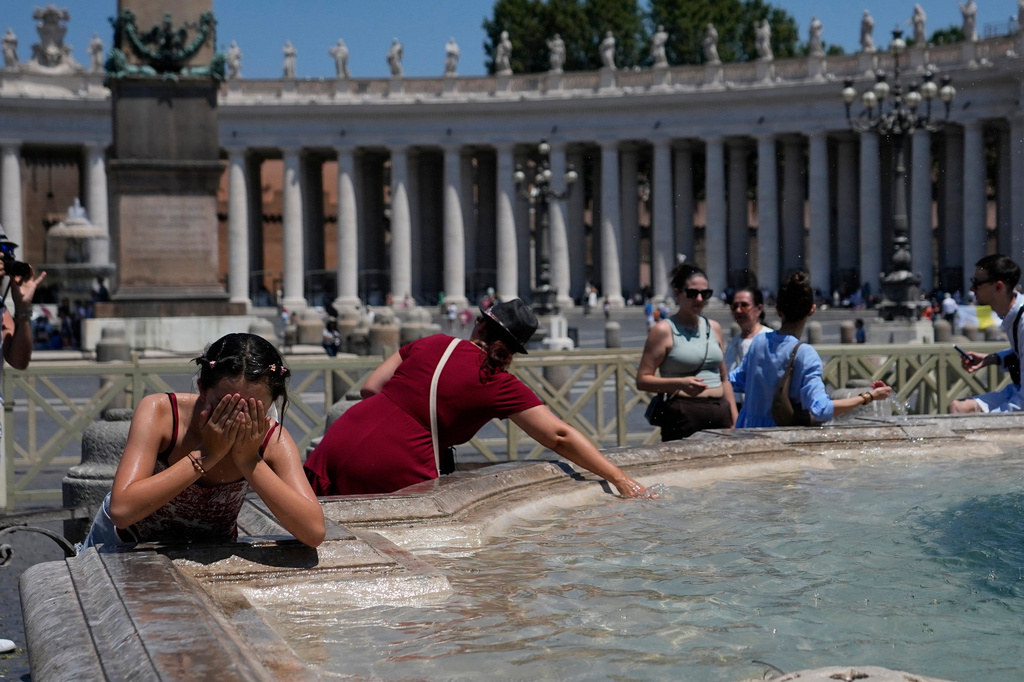 People refresh in a fountain after the Angelus noon prayer celebrated by Pope Leo XIV from the window of his studio overlooking St.Peter's Square, at the Vatican, Sunday, June 28, 2026. (AP Photo/Alessandra Tarantino)