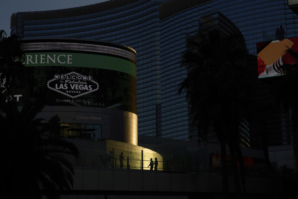 People walk across a pedestrian bridge along the Las Vegas Strip, Friday, Aug. 8, 2025, in Las Vegas. (AP Photo/John Locher)