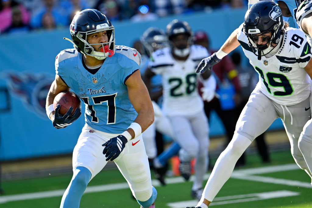 Tennessee Titans' Chimere Dike (17) runs back a punt for a touchdown as Seattle Seahawks' Jake Bobo (19) defends during the second half of an NFL football game Sunday, Nov. 23, 2025, in Nashville, Tenn. (AP Photo/John Amis)