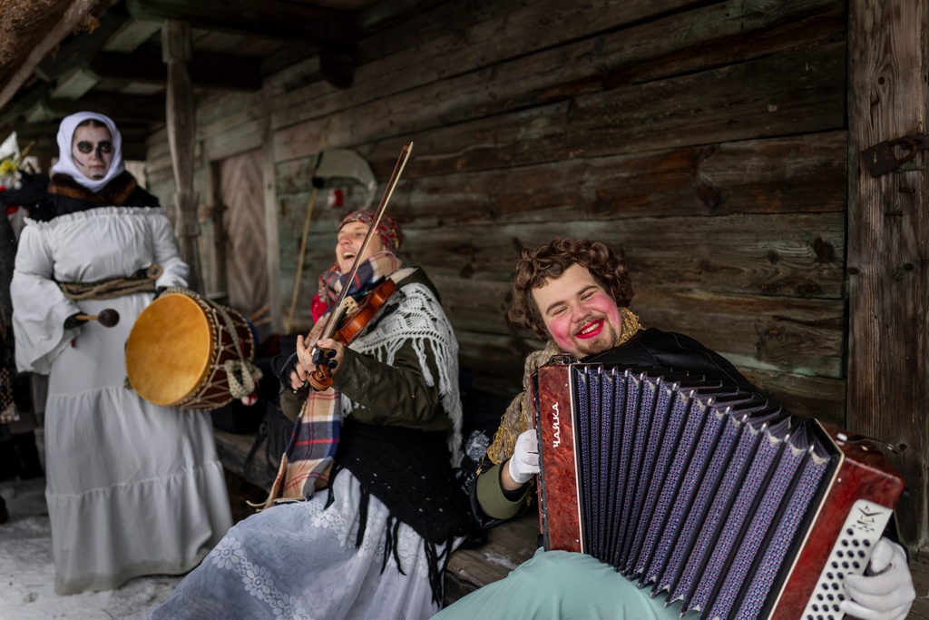Revellers wearing traditional carnival masks take part in Shrovetide celebrations in the village of Rumsiskes, some 89 kilometers (56 miles) north of Vilnius, Lithuania, Saturday, Feb. 14, 2026. (AP Photo/Mindaugas Kulbis)