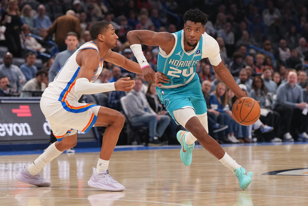 Charlotte Hornets forward Brandon Miller, right, drives past Oklahoma City Thunder guard Aaron Wiggins, left, during the second half of an NBA basketball game, Monday, Jan. 5, 2026, in Oklahoma City. (AP Photo/Kyle Phillips)