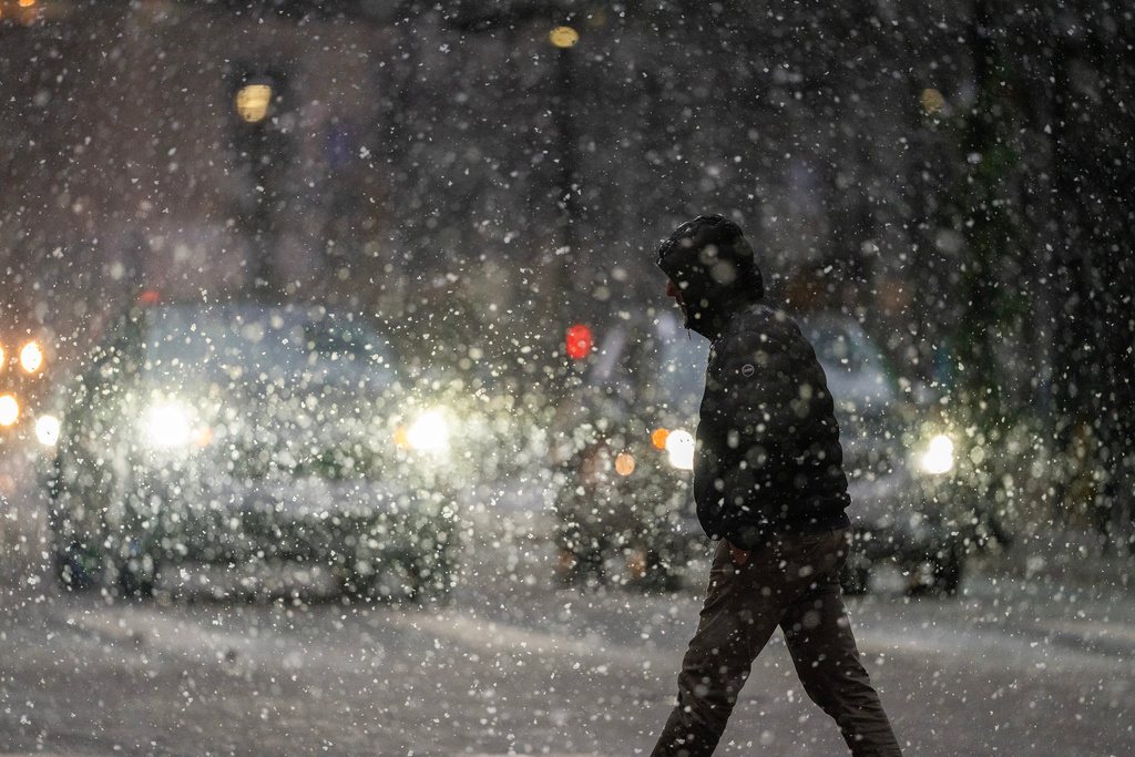 A man crosses 7th street in the heavy snow Sunday Dec. 28, 2025 in downtown Minneapolis. (Jerry Holt /Star Tribune via AP)