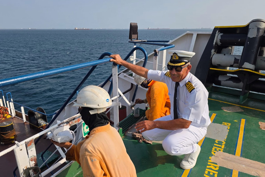 In this picture courtesy of Captain Rahman Al-Jubouri, he, right, supervises sailors on the deck of the Sea Moon oil tanker on the waters the Gulf of Oman, Wednesday, April 15, 2026. (Photo courtesy of Capt. Rahman Al-Jubouri via AP)