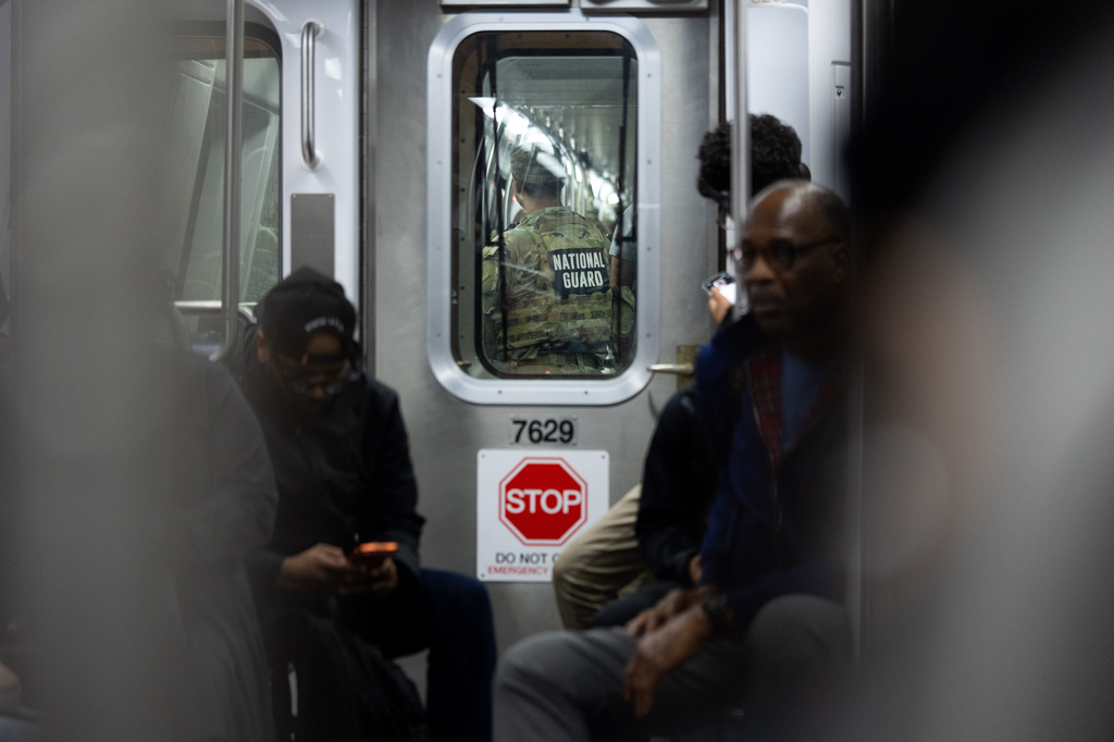 FILE - A member of the National Guard rides the Metro, March 23, 2026, in Washington. (AP Photo/Allison Robbert, File)