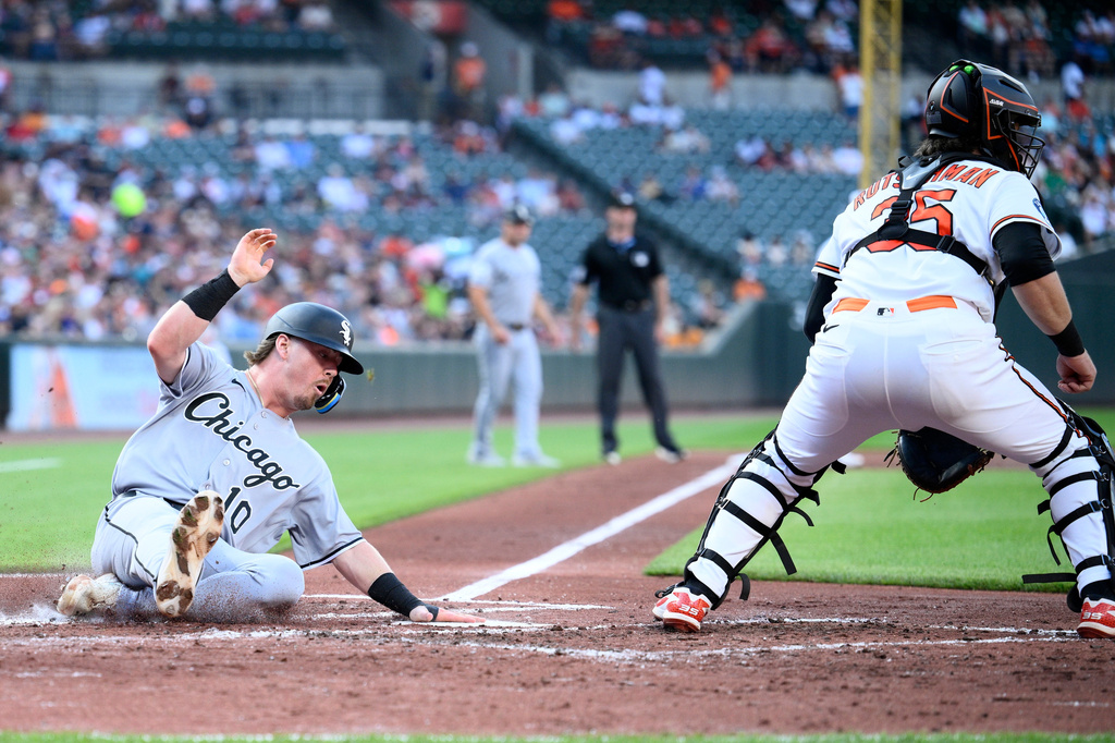 Chicago White Sox's Chase Meidroth, left, slides home to score against Baltimore Orioles catcher Adley Rutschman, right, on a double hit by teammate Jacob Gonzalez during the third inning of a baseball game, Monday, June 29, 2026, in Baltimore. (AP Photo/Nick Wass)