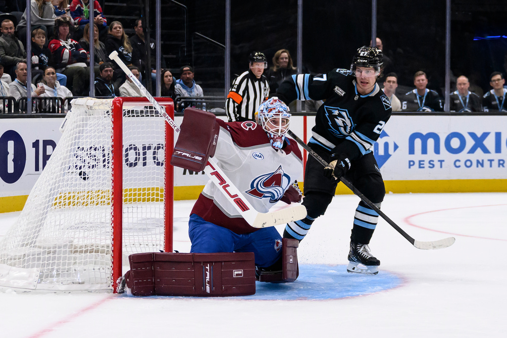 The puck goes into the net past Colorado Avalanche goaltender Scott Wedgewood, left, from a shot by Utah Mammoth right wing Dylan Guenther, not pictured, during the second period of an NHL hockey game, Wednesday, Feb. 25, 2026, in Salt Lake City. (AP Photo/Tyler Tate)