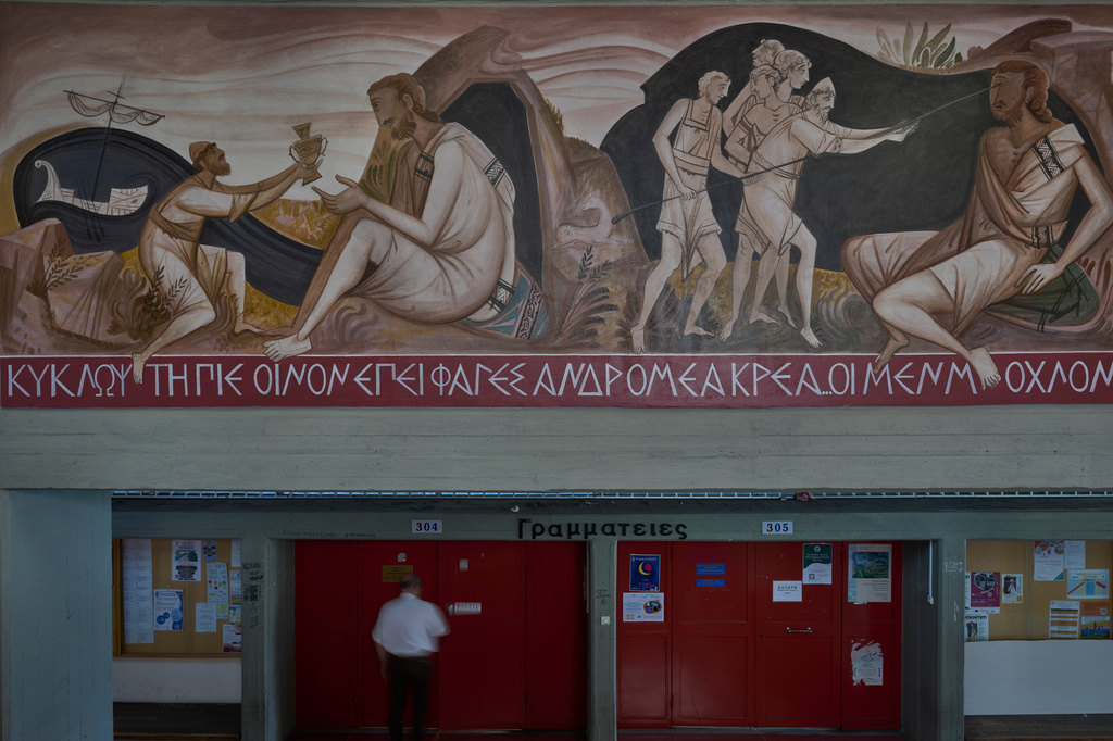 A man walks past a mural by George Kordis depicting Odysseus blinding the Cyclops Polyphemus at the School of Philosophy of the National and Kapodistrian University of Athens, Wednesday, May 20, 2026. (AP Photo/Petros Giannakouris)