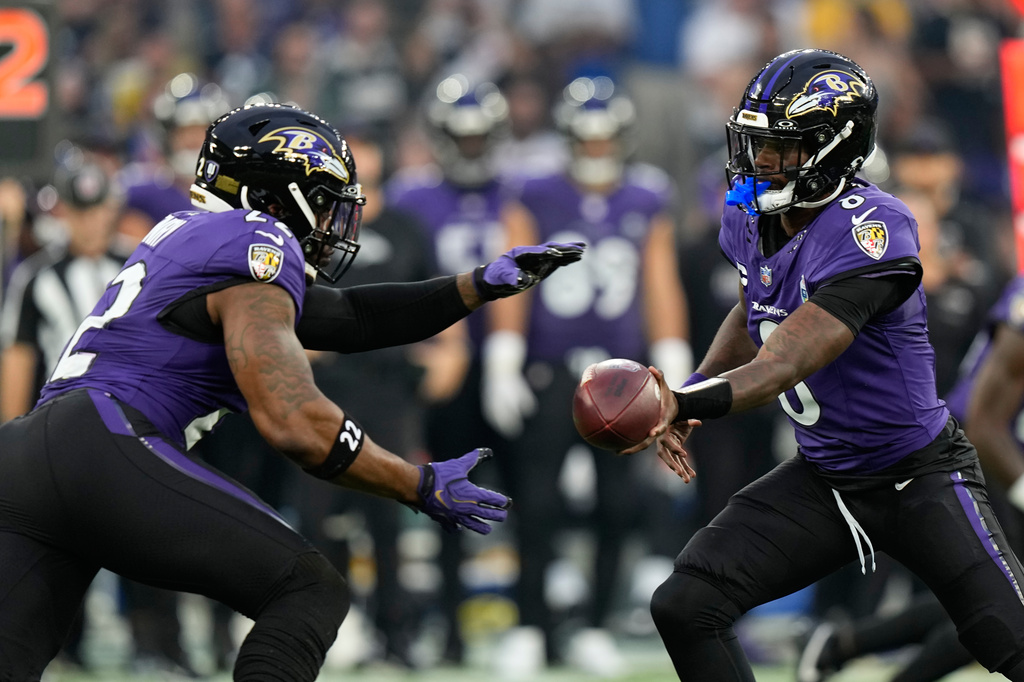 Baltimore Ravens quarterback Lamar Jackson (8) hands off to running back Derrick Henry (22) during the first half of an NFL football game in Rio de Janeiro, Sunday, Sept. 27, 2026. (AP Photo/Fernando Llano)