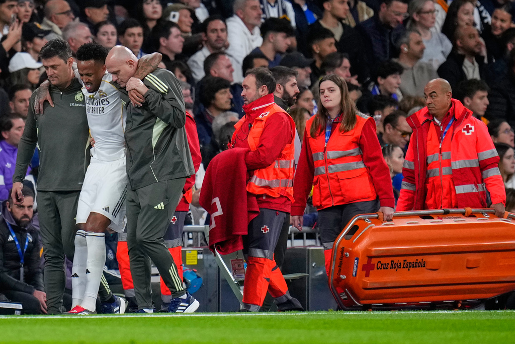 Real Madrid's Eder Militao is assisted from the pitch after getting an injury during the Spanish La Liga soccer match between Real Madrid and Celta Vigo in Madrid, Spain, Sunday, Dec. 7, 2025. (AP Photo/Manu Fernandez)