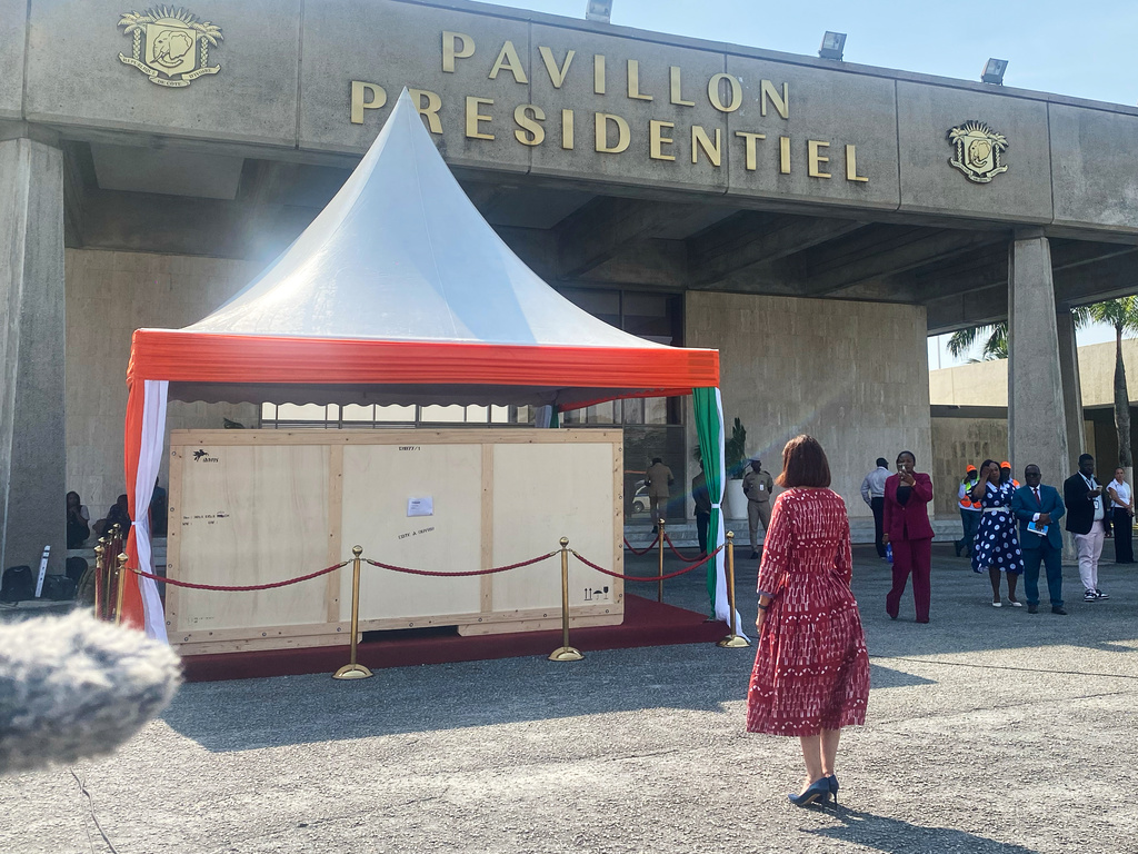 Francoise Remarck, Ivorian minister of Culture, stands in front of the crate containing a looted sacred talking drum, in Abidjan, Ivory Coast, Friday, March 13, 2026. (AP Photo/Marine Jeannin)