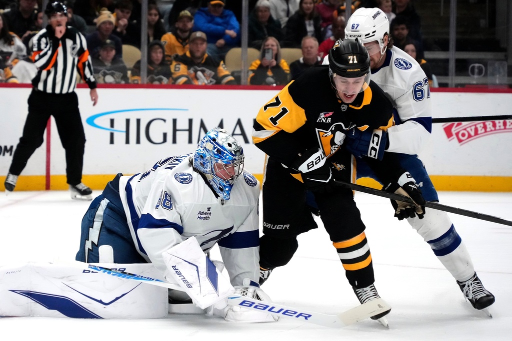 Tampa Bay Lightning goaltender Andrei Vasilevskiy (88) smothers the puck before Pittsburgh Penguins' Evgeni Malkin (71) can get his stick on it with Declan Carlile (67) defending during the second period of an NHL hockey game in Pittsburgh, Tuesday, Jan. 13, 2026. (AP Photo/Gene J. Puskar)
