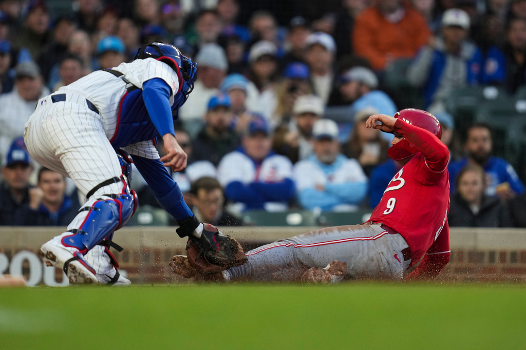 Chicago Cubs catcher Carson Kelly, left, tags out Cincinnati Reds' Matt McLain (9) at home during the third inning of a baseball game, Wednesday, May 6, 2026, in Chicago. (AP Photo/Erin Hooley)