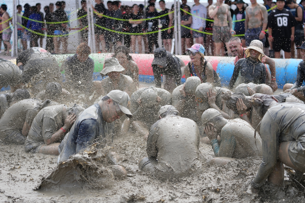 People play in a mud pool during the Boryeong Mud Festival near a beach in Boryeong, South Korea, Saturday, July 25, 2026. (AP Photo/Lee Jin-man)