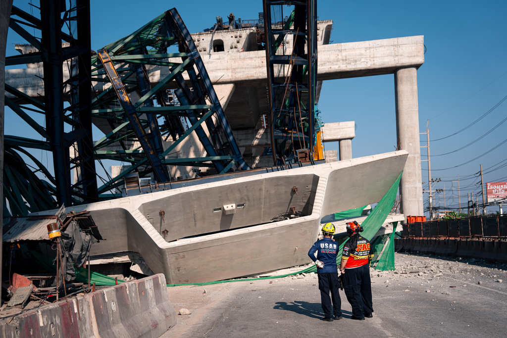 Rescuers look at a construction crane that collapsed on the Rama 2 Road elevated expressway in Samut Sakhon province, Thailand on Thursday, Jan. 15, 2026. (AP Photo/Arnun Chonmahatrakool)