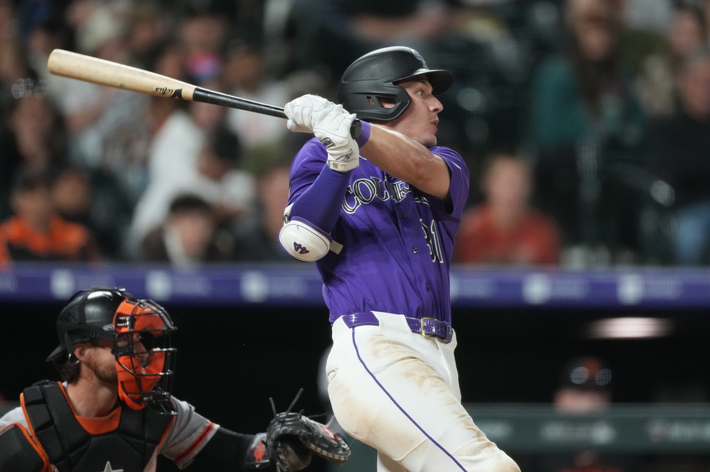 Colorado Rockies' Jake McCarthy follows the flight of his RBI single off San Francisco Giants relief pitcher Ryan Borucki in the seventh inning of a baseball game Saturday, May 30, 2026, in Denver. (AP Photo/David Zalubowski)