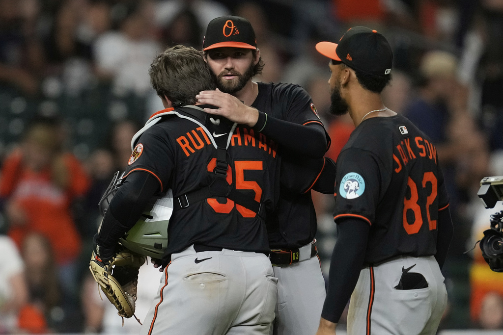 Baltimore Orioles starting pitcher Brandon Young, center, is greeted by catcher Adley Rutschman (35) after winning a baseball game against the Houston Astros in Houston, Friday, Aug. 15, 2025. (AP Photo/Ashley Landis)
