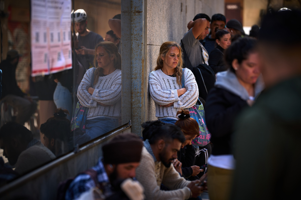 Migrants queue outside Barcelona City Hall to obtain paperwork needed to apply for Spain's immigration amnesty, which could allow hundreds of thousands of people to obtain legal status, in Barcelona, Spain, Monday, April 20, 2026. (AP Photo/Emilio Morenatti)