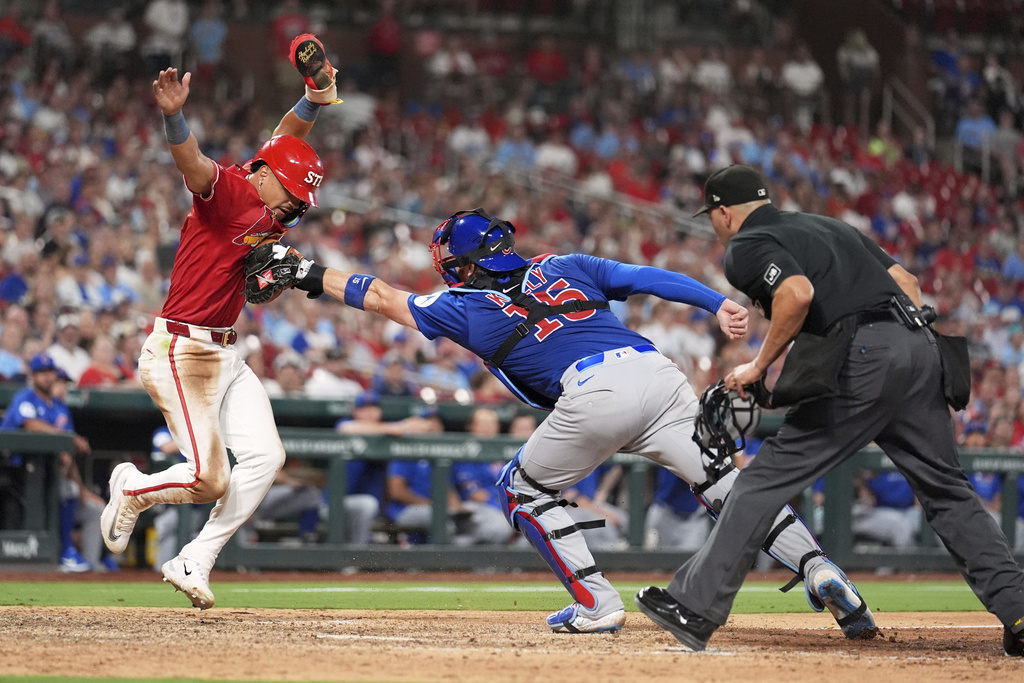 St. Louis Cardinals' Masyn Winn, left, is tagged out at home by Chicago Cubs catcher Carson Kelly as home plate umpire Roberto Ortiz, right, prepares to make the call during the eighth inning of a baseball game Friday, Aug. 8, 2025, in St. Louis. (AP Photo/Jeff Roberson)