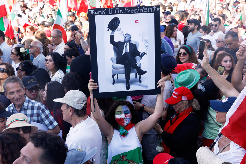 A woman holds a photo of President Trump during a demonstration in support of the U.S. and Israeli strikes on Iran on Sunday, March 1, 2026, in Los Angeles. (AP Photo/Jill Connelly)