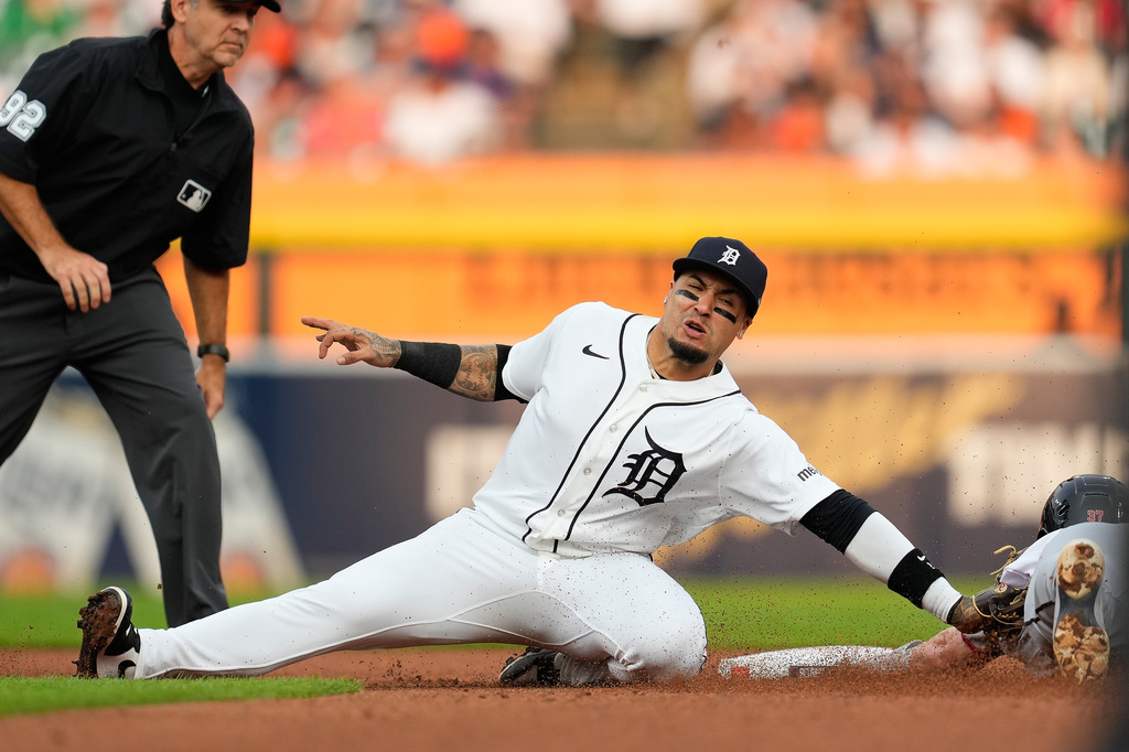 Detroit Tigers shortstop Javier Báez, left, tags Cleveland Guardians' Travis Bazzana out attempting to steal second base during the fourth inning of a baseball game Tuesday, Aug. 11, 2026, in Detroit. (AP Photo/Paul Sancya)