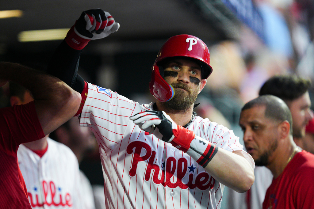Philadelphia Phillies' Bryce Harper celebrates in the dugout after hitting a solo home run off Toronto Blue Jays pitcher Max Scherzer during the sixth inning of a baseball game, Saturday, Aug. 8, 2026, in Philadelphia. (AP Photo/Derik Hamilton)