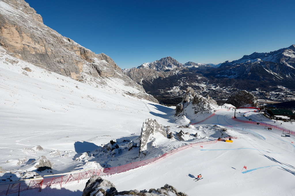 FILE - A skier is framed by the Dolomites landscape as she speeds down the Tofane course during an alpine ski, women's World Cup downhill training, venue for the alpine ski discipline at the Milan Cortina 2026 Winter Olympics, in Cortina d'Ampezzo, Italy, Friday, Jan. 17, 2025. (AP Photo/Alessandro Trovati, File)