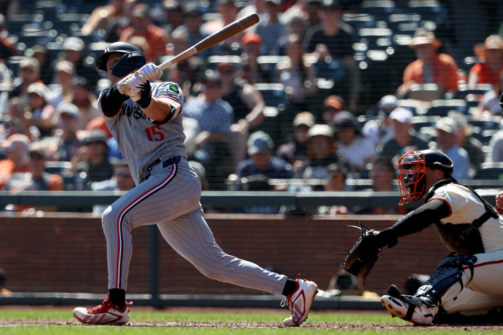 Minnesota Twins' Luke Keaschall (15) watches a solo home run in front of San Francisco Giants catcher Andrew Knizner, right, during the third inning of a baseball game in San Francisco, Wednesday, Sept. 23, 2026. (AP Photo/Jed Jacobsohn)