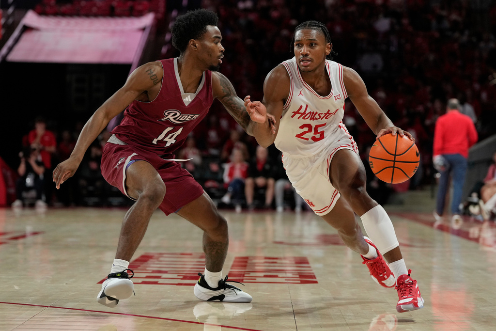 Houston guard Mercy Miller (25) drives around Rider guard Antwan Wilson (14) during the second half of an NCAA college basketball game Thursday, Nov. 20, 2025, in Houston. (AP Photo/Kevin M. Cox)